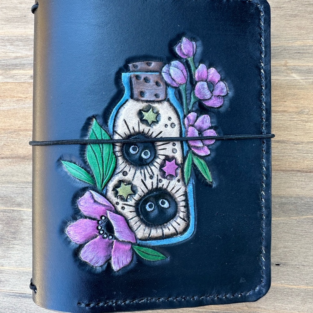 Handcrafted Black Leather Travelers Notebook with soot sprites in a jar